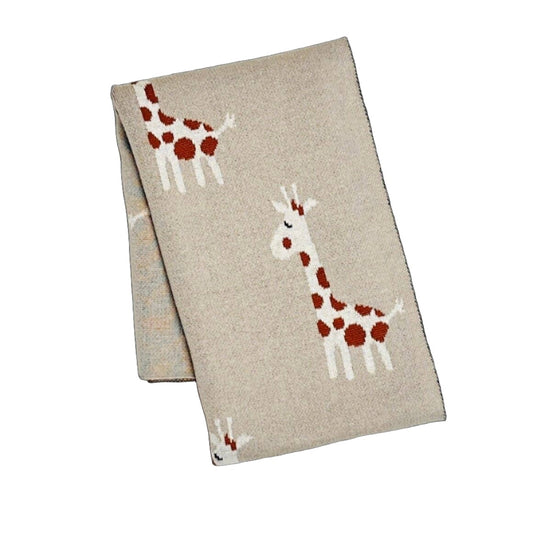 Taupe knit baby blanket folded to display a jacquard design of two white giraffes with red spots, one standing upright and one bending down, set against a textured background
