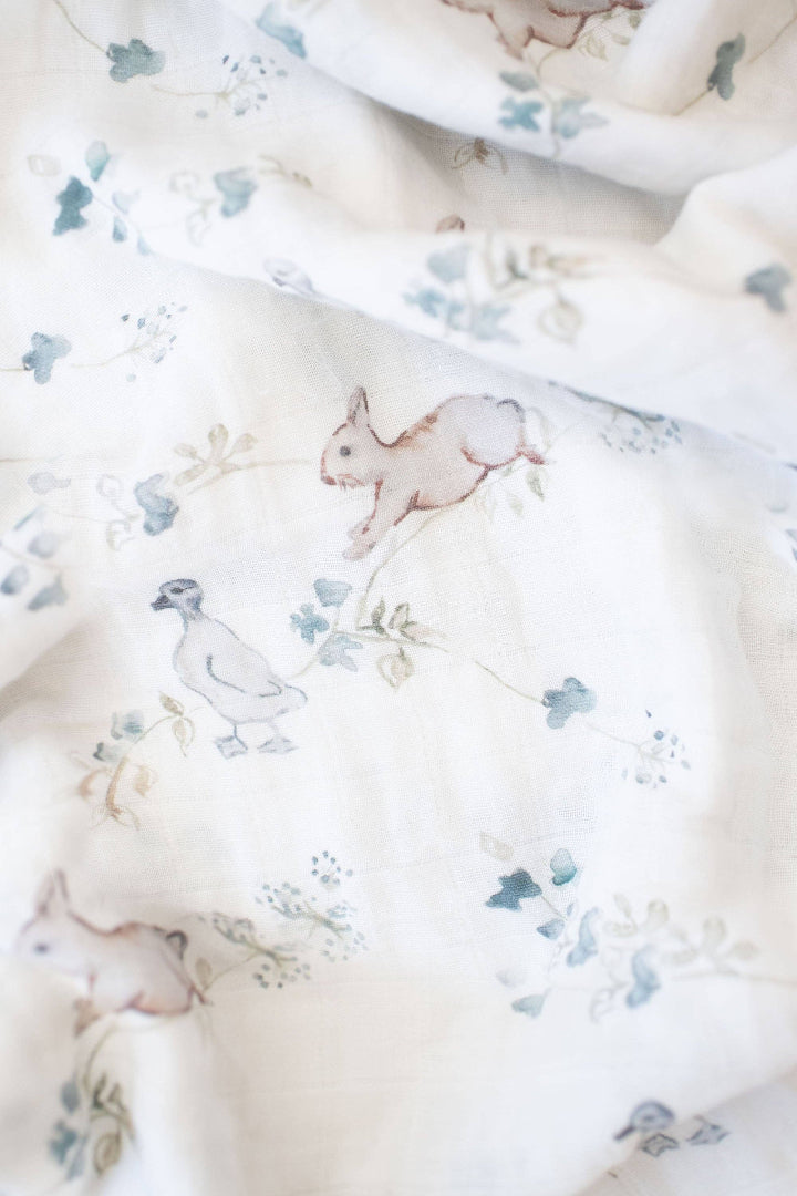 Floral fabric with small animal illustrations on a white background
