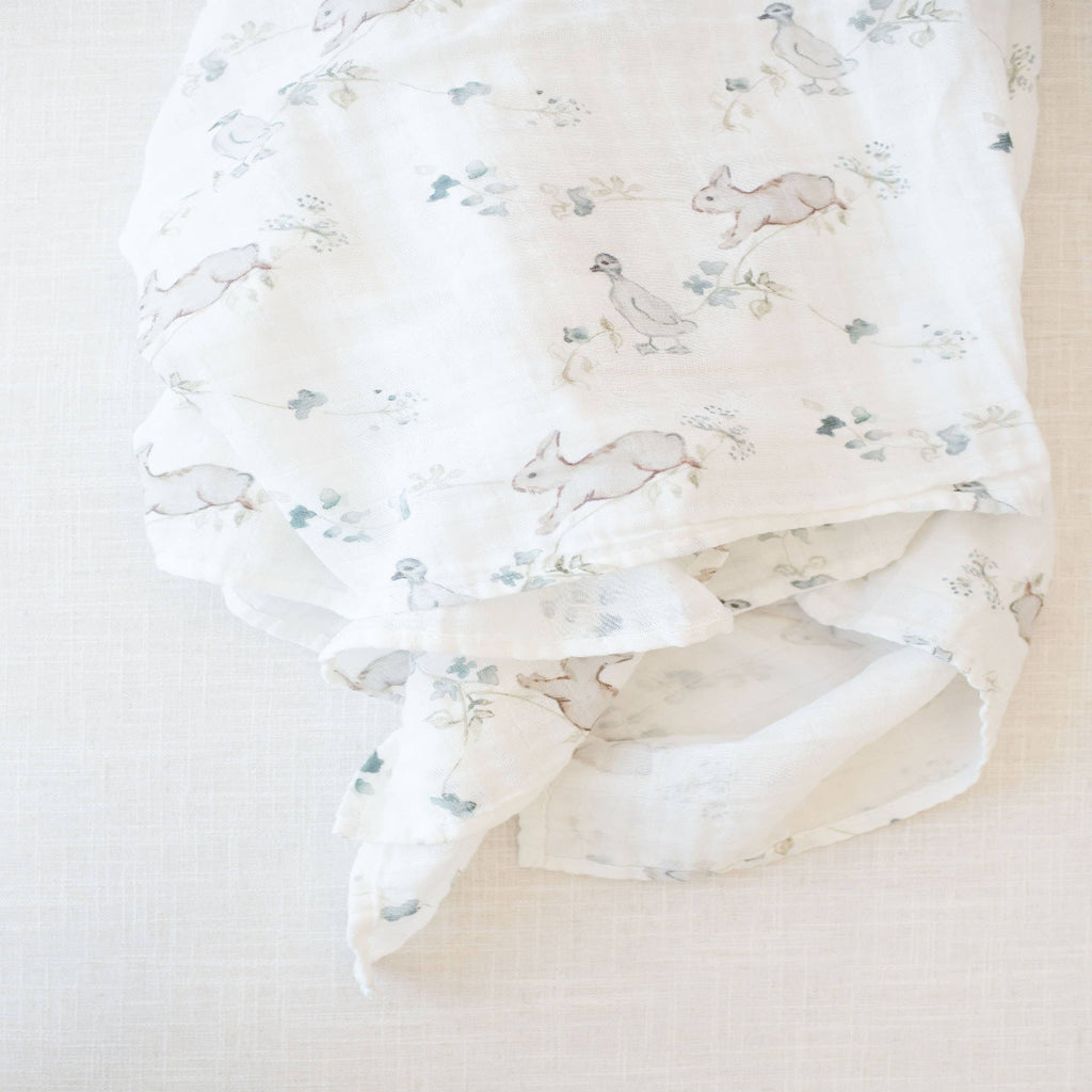 Floral patterned fabric with small animal designs on a plain background