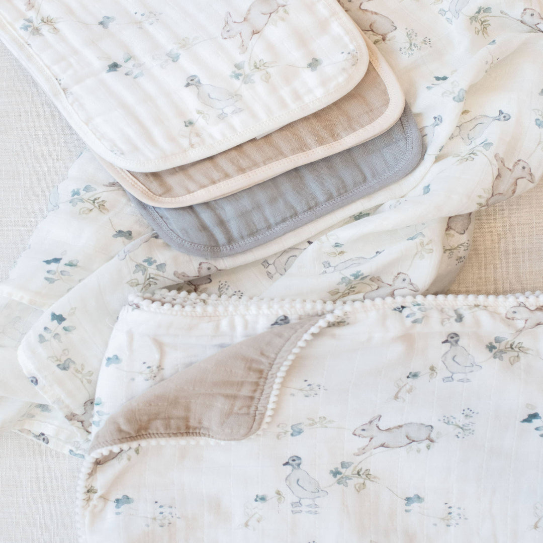 Stack of baby blankets with floral patterns on a light background